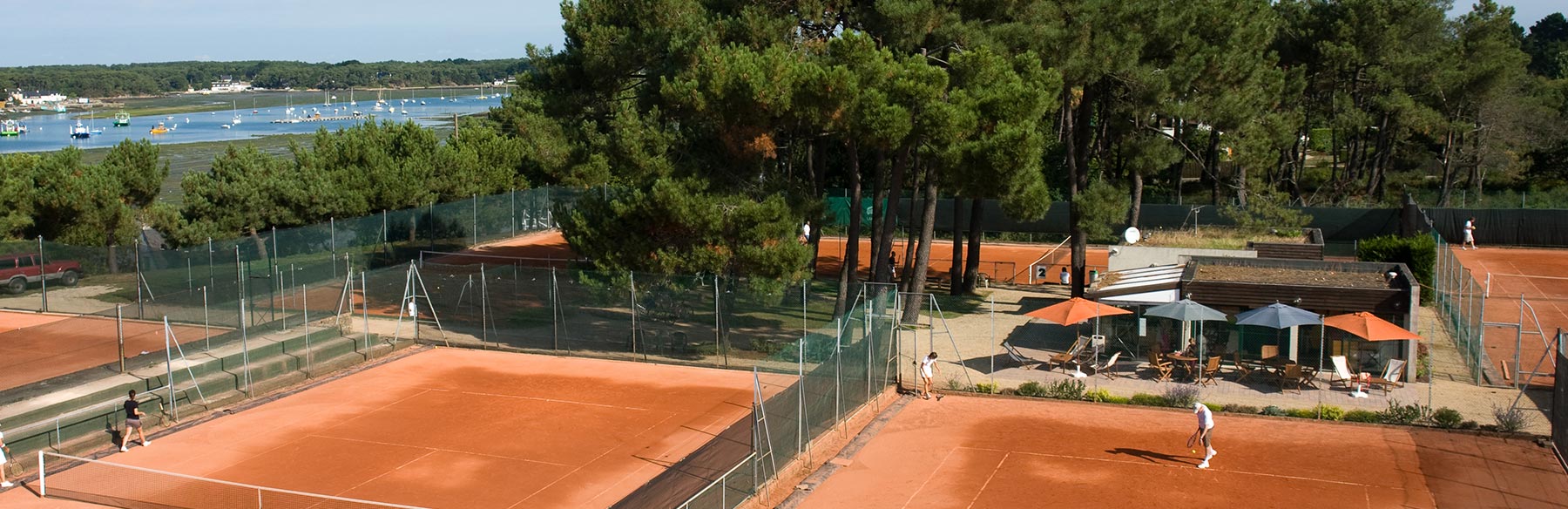 Le Club House du Tennis Club de Quehan avec vue sur courts.